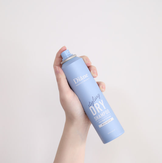 holding Perfect Beauty Styling Dry Shampoo Volume Up with white background
