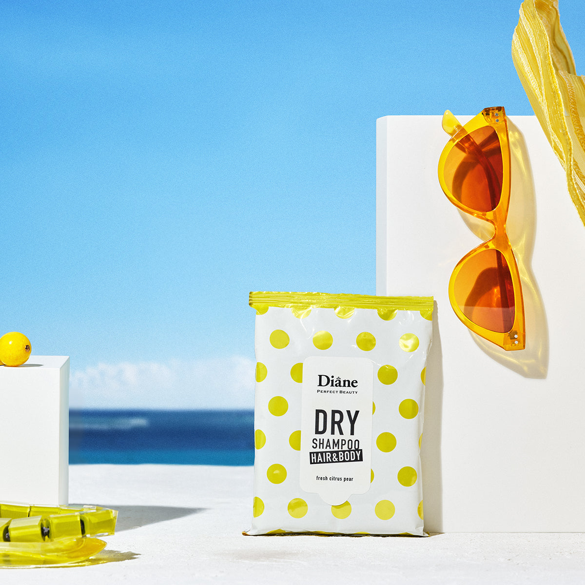 Dry shampoo with polka dot design and sunglasses on a beach background